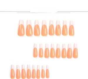 Detail view of long coffin press-on nails with peach orange French tips and glossy finish