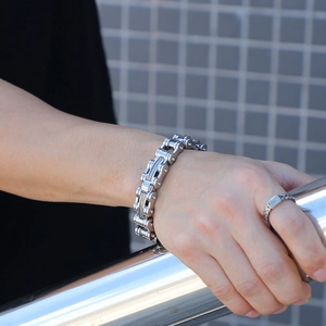 Detail shot of a silver stainless steel bicycle chain bracelet on a male model's wrist