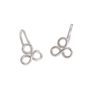 Détail macro de clips d'oreilles triple anneaux entrelacés en argent finition polie