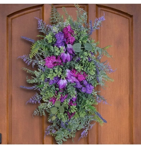 Detail of purple and pink tulips with eucalyptus leaves on a dark wooden door