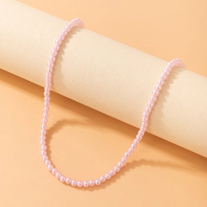 Close-up of elegant pink pearl beaded necklace draped over a minimalist prop stand