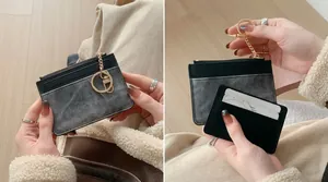 Slim black leather card holder with denim texture and gold zipper shown in use