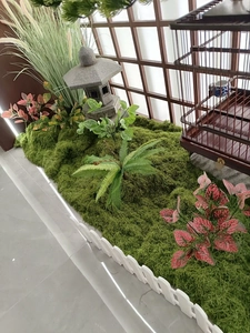 Detailed close-up of artificial moss turf with mini stone lantern and fence decor