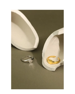 Detailed view of silver and gold sunburst engraved rings with zircon on stone