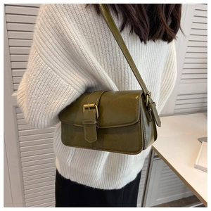 Detail of olive green vintage leather crossbody bag with adjustable strap and gold buckle
