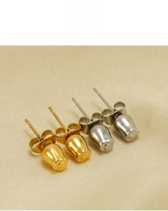 Detail von Gold- und Silber-Ohrsteckern mit 18K Vakuumplattierung auf Seidenhintergrund