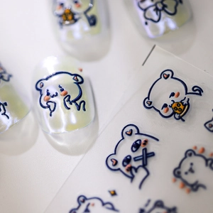 3D embossed bear nail stickers with blue outlines and orange details on white nails