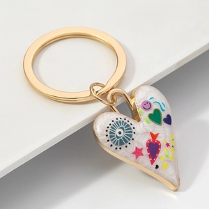 Détail du porte-clés en alliage d'or en forme de cœur avec émail coloré et motifs graffiti