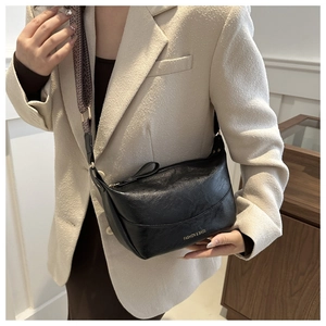 Dettaglio borsa a mezzaluna in pelle PU nera vintage con ampia tracolla intrecciata