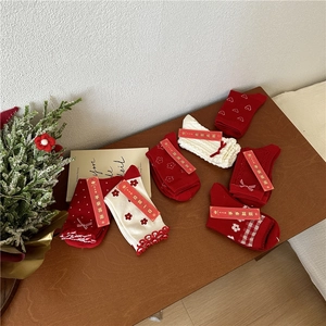 Detail of red and cream festive socks with knit textures and New Year gift tags