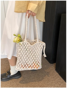 Detailed macro view of beige hollow-out handmade woven bag with cotton rope texture