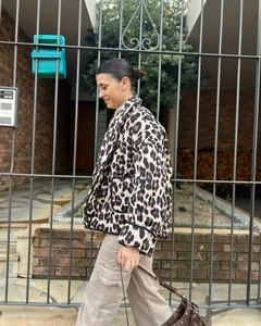 Detail of leopard print quilted jacket with black trim and stand collar on model