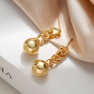 Minimalist gold plated chain drop earrings with spherical charms on a satin background