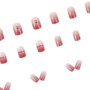 Pink and red gradient press-on nails with cute stars and eye patterns in a glossy finish