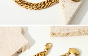 Macro shot of 18K gold plated Cuban chain with freshwater pearl and seashell pendant