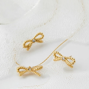 Parure élégante collier et boucles d'oreilles nœud doré avec cristaux sur dentelle