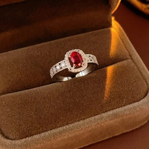 Detail view of oval red gemstone ring with micro-pave zircons and silver finish