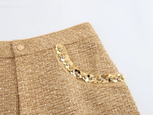 Detail of tweed skirt with gold sequins and rhinestones on the pocket and waist
