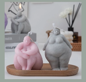 Artistic body shaped candles in pink and grey showing detailed female silhouette forms