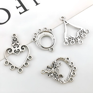 Detailed macro view of four vintage silver alloy pendants with floral hollow engravings