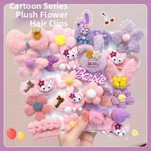 Detail of plush cartoon hair clips with Barbie and flower motifs on display card