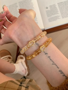 Vue détaillée d'un bracelet double rang en perles de cristal jaune et pendentif coeur