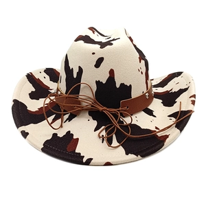 Detail of cow print cowboy hat showing leather strap with silver rivets and felt texture