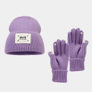 Detailed close-up of purple knit beanie and gloves set with white decorative textile label