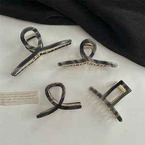 Lot de 4 grandes pinces à cheveux à motif marbre gris et noir sur table blanche