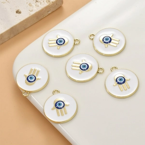 Detailed view of six golden Hamsa Hand charms with blue evil eye and white enamel
