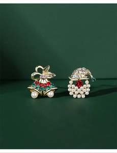 Close-up of Christmas earrings with golden bells, red rhinestones and white pearls