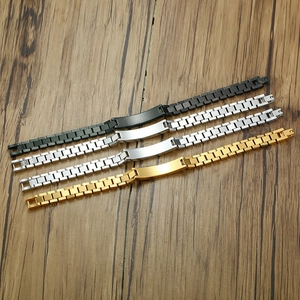 Group of black, gold, and silver titanium steel curb bracelets on a wooden surface