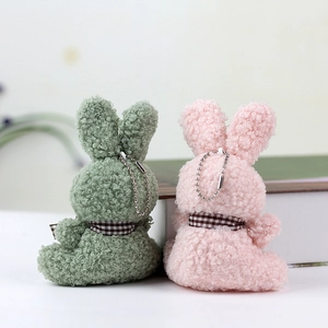Detail of green and pink plush bunny pendants with teddy fur and checkered ribbons