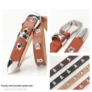 Detail view of colorful faux leather belts with hollow flower eyelets and silver buckles