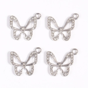 Macro view of silver butterfly pendants with white zircon stones for jewelry making