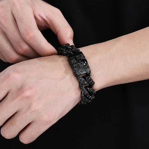 Close-up of black punk skull bracelet with vintage cuban chain details on wrist