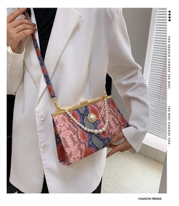 Détail du sac à main imprimé serpent avec chaîne en perles et boucle en diamant chic