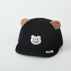 Détail de la casquette bébé en velours côtelé avec oreilles et broderie d'ours