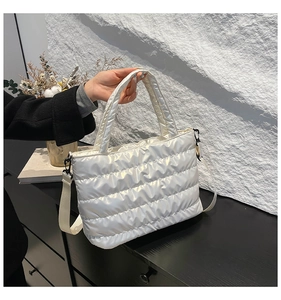 Close-up of pearl white quilted puffer bag with glossy nylon finish and shoulder strap