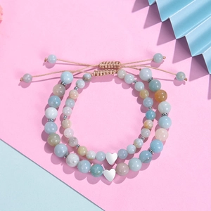 Pink and blue natural stone beaded bracelets with heart charms on colorful background