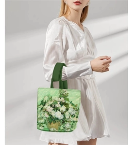 Detail of green tote bag featuring Van Gogh Roses oil painting print held by a model