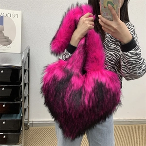 Detailed close-up of heart-shaped plush tote bag in pink and black faux fur texture