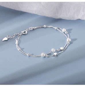 Detail of a double-layered silver star bracelet with frosted beads and lobster clasp