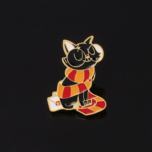 Detail of an enamel pin featuring a black cat with glasses on a white envelope