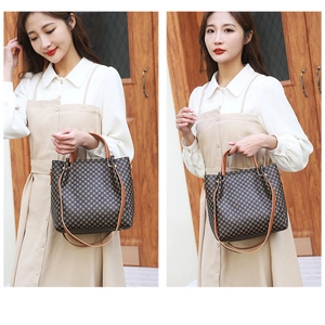 Brown checkered handbag with leather handles shown on a model for size perspective