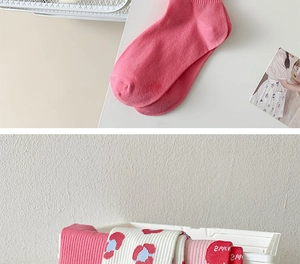 Detail of pink knit socks and floral jacquard patterns in a white storage basket