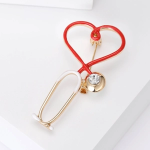 Golden stethoscope brooch with red enamel heart and crystal detail for medical professionals