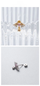 Detailed close-up of gold and silver heart wing earrings with pink zircon and star charms