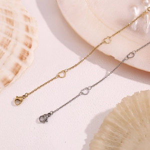 Detail of heart link anklets in gold and silver finish with lobster clasp closure