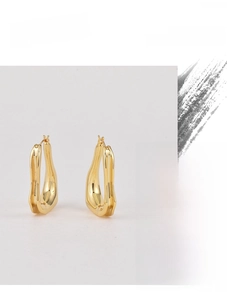 Macro detail of high quality gold irregular wavy earrings with a polished smooth finish